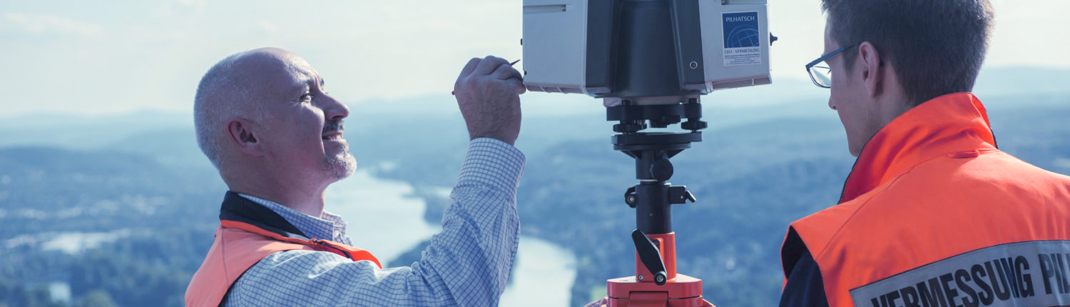 Headerbild Amtliche Vermessung: Zwei Mitarbeiter von Pilhatsch Ingenieure verwenden den Laserscanner