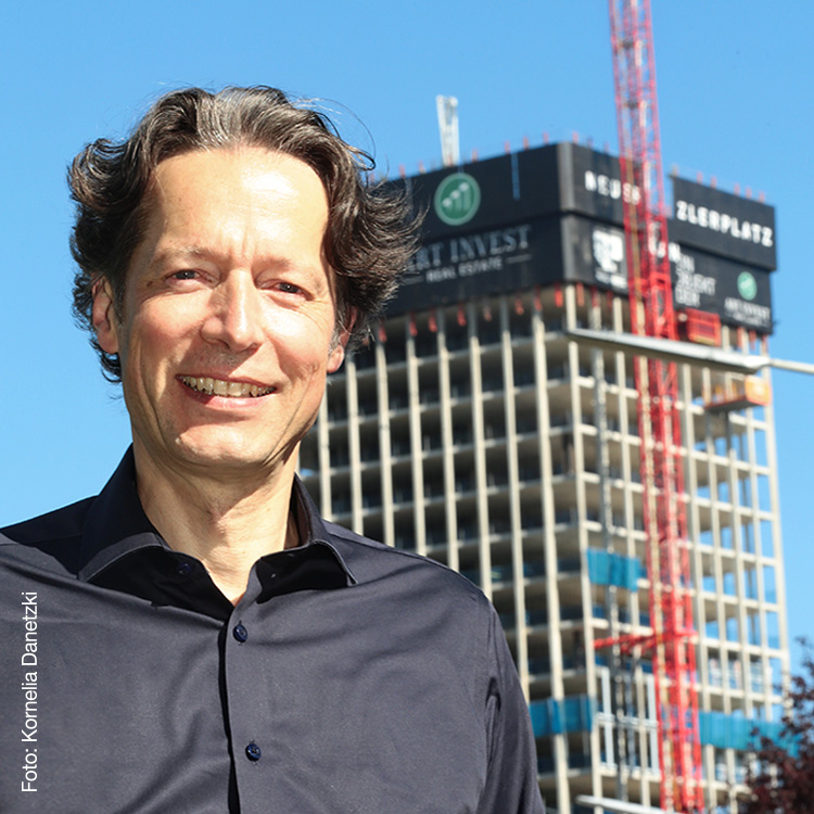 Martin Pilhatsch steht vor einem Gebäude mit Art-Invest Bannern